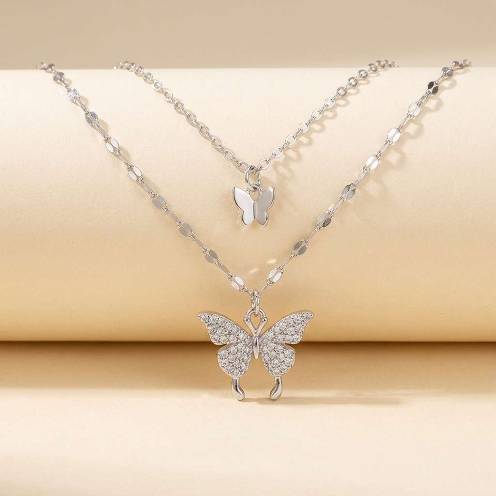 Silver-tone layered butterfly necklace on an ivory background