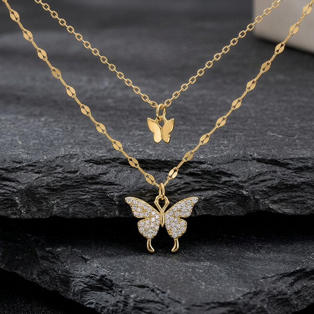 Gold-tone butterfly pendants and two chains on charcoal stone