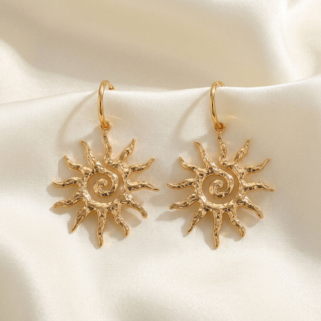Pair of gold-tone spiral sun drop earrings on ivory silk