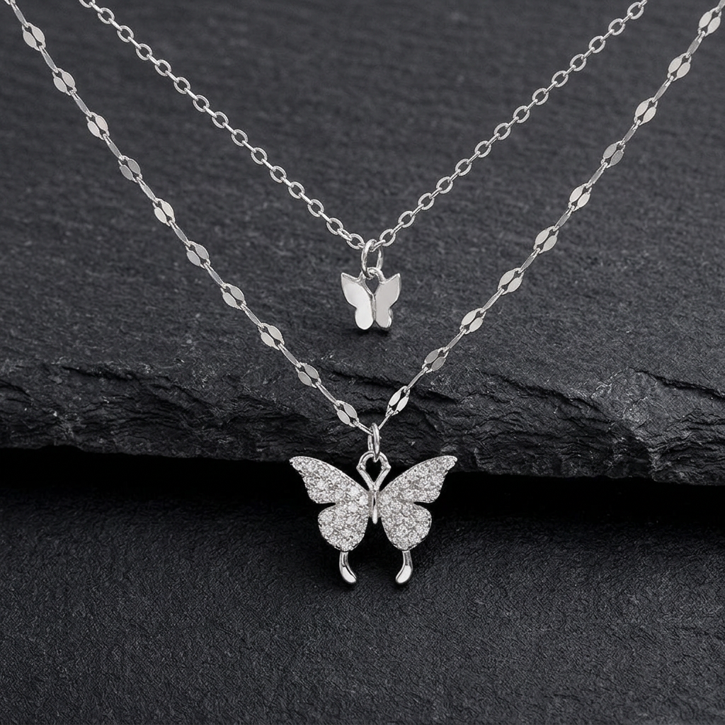 Silver-tone butterfly pendants and two chains on charcoal stone